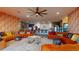 Bright living room featuring orange couches, modern lighting, and an open concept design at 10787 Oak Ne St, St Petersburg, FL 33716