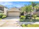 Charming single-Gathering home showcasing a well-manicured lawn, mature palms and a two-car garage at 10809 River Hawk Lane, Riverview, FL 33569