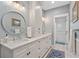 Bathroom with double sinks, a white vanity, a large round mirror and a separate shower room at 1100 Cordova Ne Blvd, St Petersburg, FL 33704