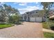Two story home showcasing a lush landscaped yard, brick driveway, and a two car garage at 1100 Cordova Ne Blvd, St Petersburg, FL 33704