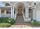 Charming covered front porch with brick steps and pillars to an impressive wood door at 1100 Cordova Ne Blvd, St Petersburg, FL 33704