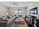Living room featuring a large sofa, entertainment center, ceiling fan and outside water view from sliding glass door at 1100 Cordova Ne Blvd, St Petersburg, FL 33704
