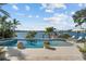 A beautiful waterfront pool with a serene view of the bay, palm trees, and inviting lounge chairs at 1100 Cordova Ne Blvd, St Petersburg, FL 33704