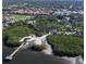 Stunning coastal aerial view featuring a serene beach, dock, lush greenery, and nearby residences at 1259 Ribolla Dr, Palm Harbor, FL 34683