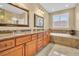 Bathroom with double sinks, wood cabinets and soaking tub at 1259 Ribolla Dr, Palm Harbor, FL 34683