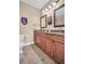 Bathroom with double sinks, granite counters and wooden cabinets at 1259 Ribolla Dr, Palm Harbor, FL 34683