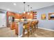 Well-equipped kitchen with wood cabinets, barstool seating, stainless steel appliances, and stylish pendant lighting at 1259 Ribolla Dr, Palm Harbor, FL 34683
