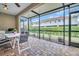 Screened patio area with brick flooring, a ceiling fan, and an outdoor dining set at 1259 Ribolla Dr, Palm Harbor, FL 34683