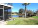 View of pond, golf course, grassy yard, trees and covered patio at 130 Water Oak Way, Oldsmar, FL 34677