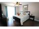 Cozy bedroom features a ceiling fan, dark wood floors, and bright natural light at 130 Water Oak Way, Oldsmar, FL 34677