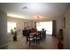 Bright dining room features tile floors, large window, decorative chandelier, and seating for eight at 130 Water Oak Way, Oldsmar, FL 34677
