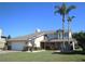 Charming two-story home with manicured lawn, mature palm trees, and an attached two-car garage at 130 Water Oak Way, Oldsmar, FL 34677
