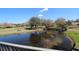 Pond on golf course with golf cart and bridge are seen from balcony at 130 Water Oak Way, Oldsmar, FL 34677