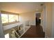 Upstairs hallway featuring hardwood floors, natural light and glass railings at 130 Water Oak Way, Oldsmar, FL 34677