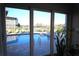 Outdoor swimming pool with paved deck viewed through sliding glass doors at 130 Water Oak Way, Oldsmar, FL 34677