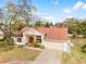 Elevated angle of home with large oak tree, covered front porch and two car garage at 13542 Summerwood Ct, Hudson, FL 34667