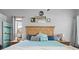 Well-lit bedroom featuring a large bed with blue accents and two bedside tables at 13542 Summerwood Ct, Hudson, FL 34667
