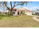 Inviting single-story home featuring a well-maintained lawn, a large tree and a two car garage at 13542 Summerwood Ct, Hudson, FL 34667