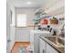 Functional laundry room featuring a sink, washer, shelves, and storage for cleaning supplies at 13542 Summerwood Ct, Hudson, FL 34667