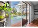 View through sliding glass doors into the screened in patio and pool at 13542 Summerwood Ct, Hudson, FL 34667