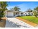 Charming single-story home featuring a well-manicured lawn, a lovely front porch, and an attached garage at 1712 25Th N Ave, St Petersburg, FL 33713