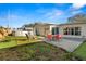 Backyard featuring a patio area with outdoor seating, a well-manicured lawn, and an above ground pool at 1942 Radcliffe N Dr, Clearwater, FL 33763