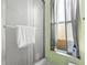 Bathroom featuring shower stall with glass door and a window with natural light at 1942 Radcliffe N Dr, Clearwater, FL 33763