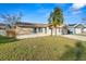 Cozy single-Gathering home with an attached two-car garage, a palm tree and a well-manicured front lawn at 1942 Radcliffe N Dr, Clearwater, FL 33763