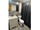 Neutral bathroom featuring a stylish vanity, toilet, and tiled walls with dark shower curtain at 204 Pine Tulip Ct # 102, Tampa, FL 33612