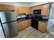 A well-lit kitchen with oak cabinets, black appliances, and tile backsplash at 204 Pine Tulip Ct # 102, Tampa, FL 33612