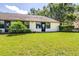 This home has a well-maintained backyard, sliding glass door and lush landscaping at 2201 Pine Dr, Tarpon Springs, FL 34689