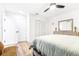 Airy bedroom with light wood floors, ceiling fan, dresser, and closet at 2201 Pine Dr, Tarpon Springs, FL 34689