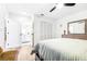 Bright bedroom with light wood floors, ceiling fan, closet and entry to the ensuite bathroom at 2201 Pine Dr, Tarpon Springs, FL 34689