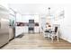 Bright kitchen featuring stainless steel appliances, white cabinetry, and a cozy dining nook at 2201 Pine Dr, Tarpon Springs, FL 34689