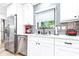 Bright and modern kitchen featuring white cabinets, stainless steel appliances, and an undermount sink at 2201 Pine Dr, Tarpon Springs, FL 34689