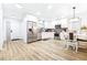Modern kitchen with stainless steel appliances, white cabinets, and adjacent dining area for easy entertaining at 2201 Pine Dr, Tarpon Springs, FL 34689