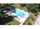 Overhead shot of a fenced in community pool surrounded by lots of mature trees at 2201 Pine Dr, Tarpon Springs, FL 34689