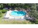 Overhead shot of a fenced in community pool surrounded by lots of mature trees at 2201 Pine Dr, Tarpon Springs, FL 34689