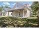 Wide backyard view showcasing covered patio, home's exterior, and generous green space at 23 N Edwards St, Plant City, FL 33563