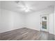 A spacious, bright bedroom with gray wood-look flooring, white walls, and a door leading to the outside at 23 N Edwards St, Plant City, FL 33563