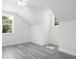 Bedroom with wood-look floors, white walls, and dormer style windows providing natural light at 23 N Edwards St, Plant City, FL 33563