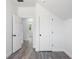 Hallway with wood-look flooring, white trim, and an open door to a sunlit room at 23 N Edwards St, Plant City, FL 33563