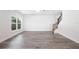 Open-concept living room with abundant natural light, staircase, and wood-look flooring at 23 N Edwards St, Plant City, FL 33563