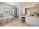 Well-lit bathroom features a soaking tub, glass shower, vanity and tile flooring at 2733 Via Cipriani # 814A, Clearwater, FL 33764