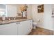 Well-lit bathroom features granite countertops, white cabinetry, and a decorative floral arrangement at 2733 Via Cipriani # 814A, Clearwater, FL 33764