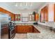 Well-lit kitchen featuring wood cabinets, granite countertops, and stainless steel appliances at 2733 Via Cipriani # 814A, Clearwater, FL 33764