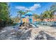Community playground featuring climbing structure, slides, sand, and palm tree views at 2733 Via Cipriani # 814A, Clearwater, FL 33764