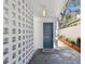 Front door and porch showcase a modern, textured concrete wall design and a neatly arranged stone pathway at 3117 W Barcelona St # A, Tampa, FL 33629