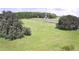 Large grassy field with treeline featuring distant transmission tower at 32817 Leonard Rd, San Antonio, FL 33576