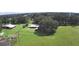Aerial view featuring a barn, shed, and fenced grounds with lush greenery at 32817 Leonard Rd, San Antonio, FL 33576